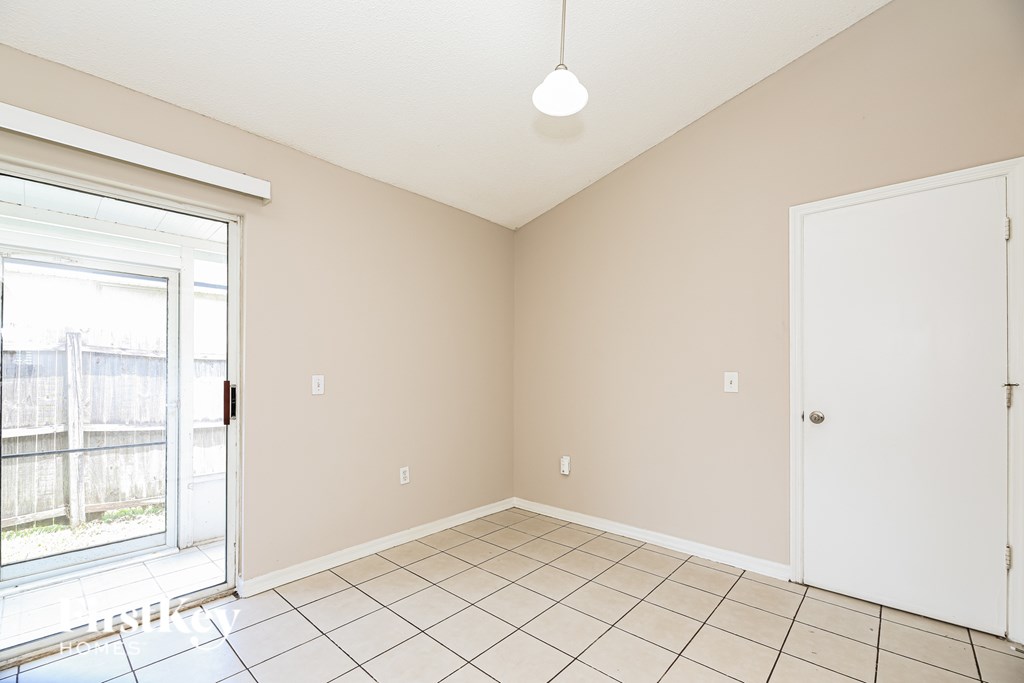 A room with a white door and a window with a sliding glass door.