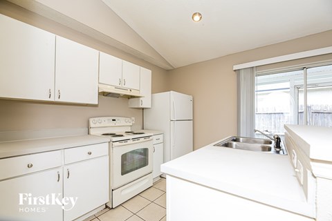 A kitchen with white appliances and cabinets.