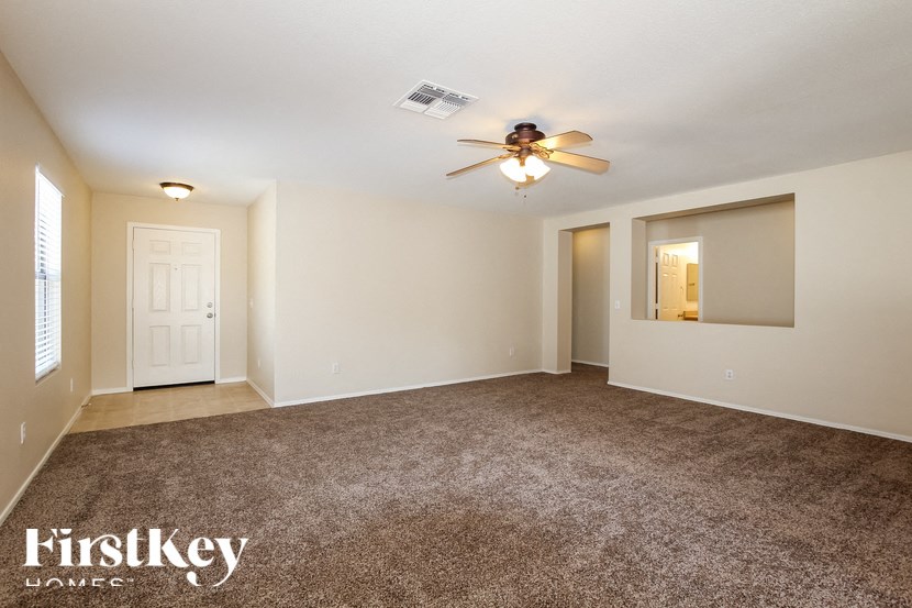 A spacious room with a ceiling fan and carpeted floor.