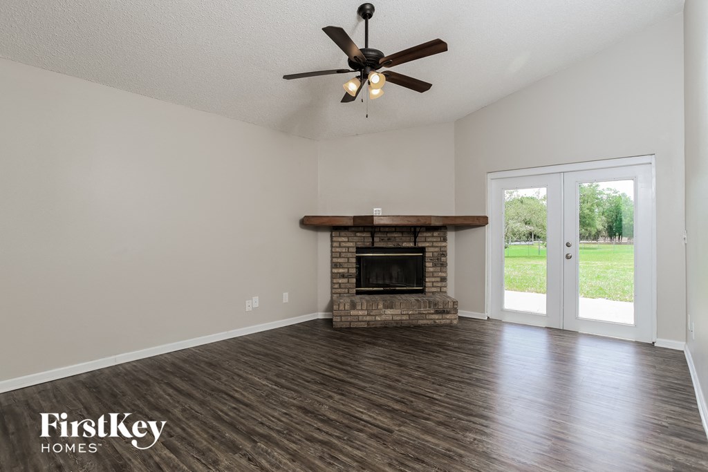 a living room with a fireplace and a ceiling fan