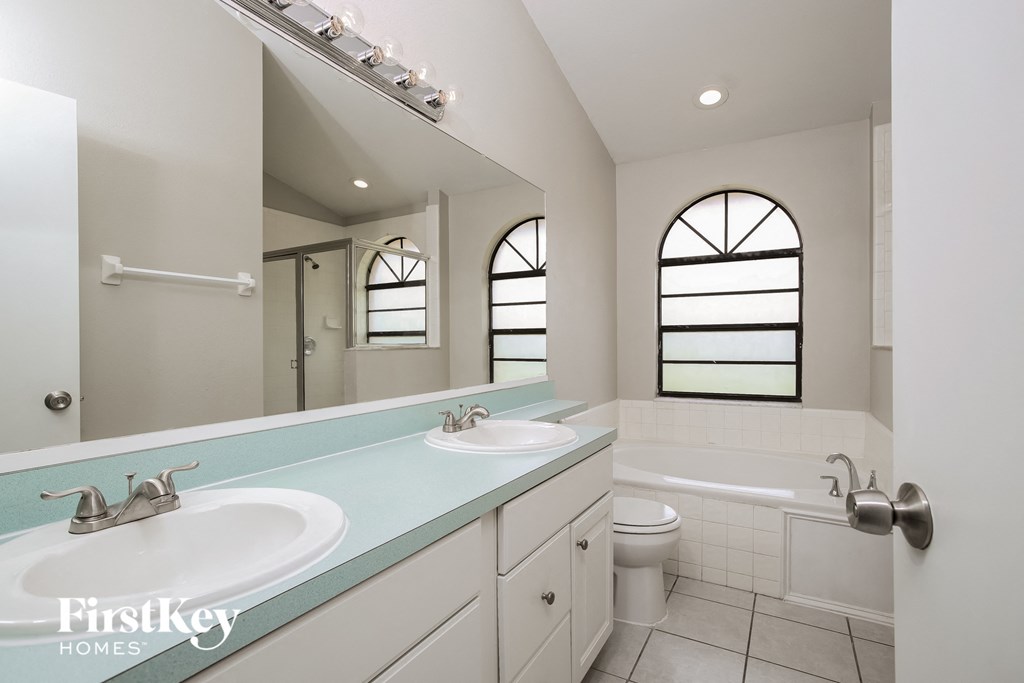 a bathroom with two sinks and a tub and a toilet