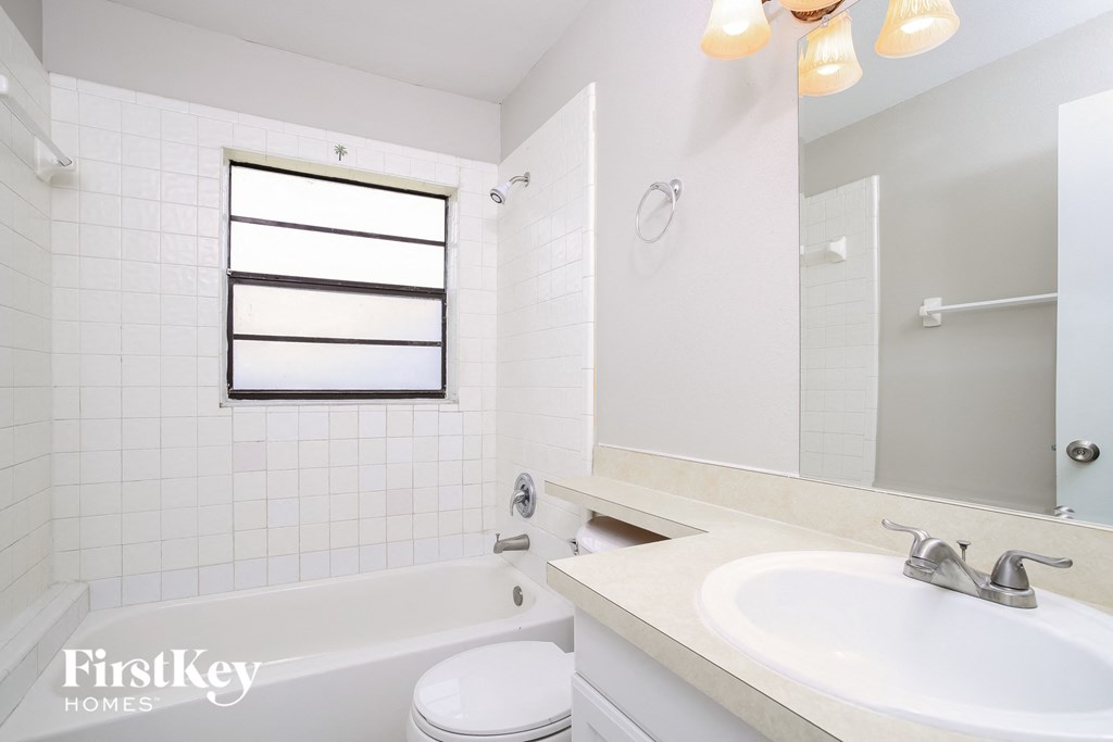 a white bathroom with a sink and a tub and a toilet