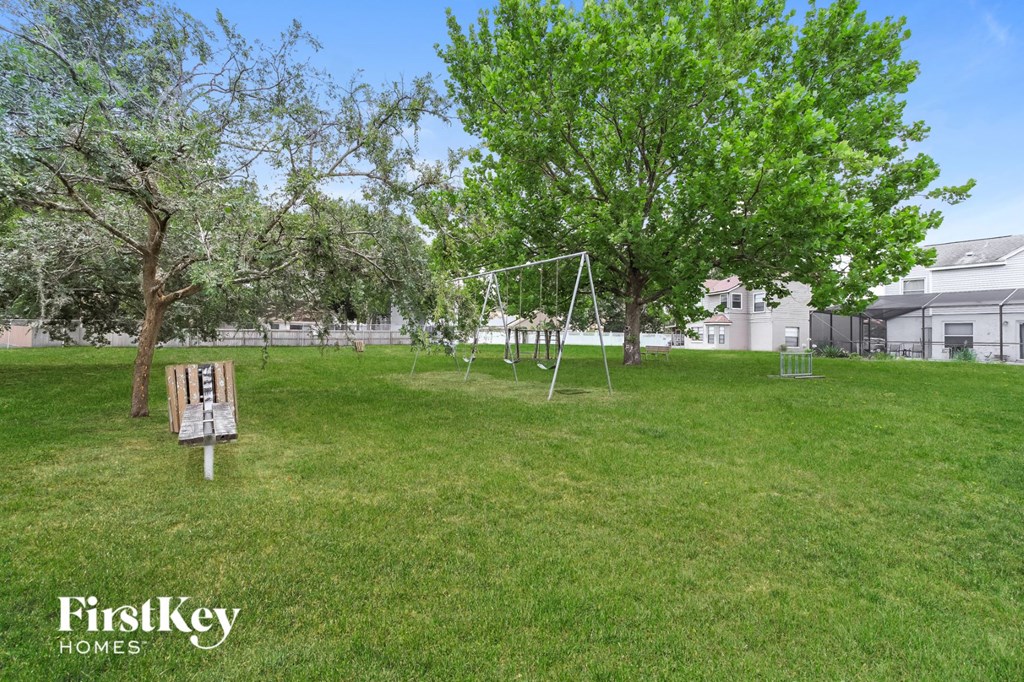 a playground in a park with trees and a swing set