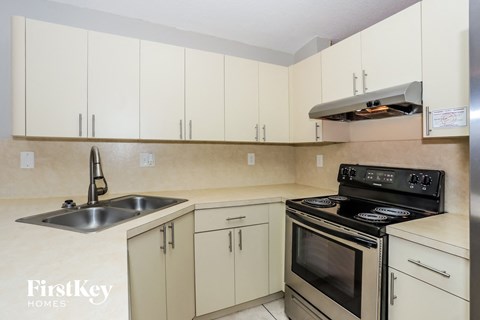 a kitchen with white cabinets and stainless steel appliances and a sink