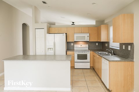 a modern kitchen with white appliances and wood cabinets