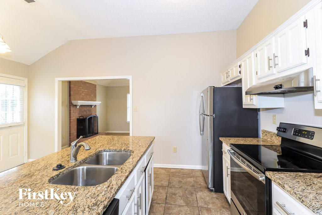 a kitchen with granite counter tops and black appliances