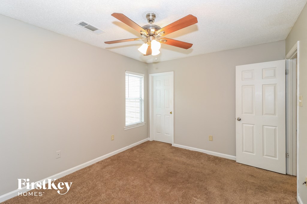 a bedroom with carpet and a ceiling fan