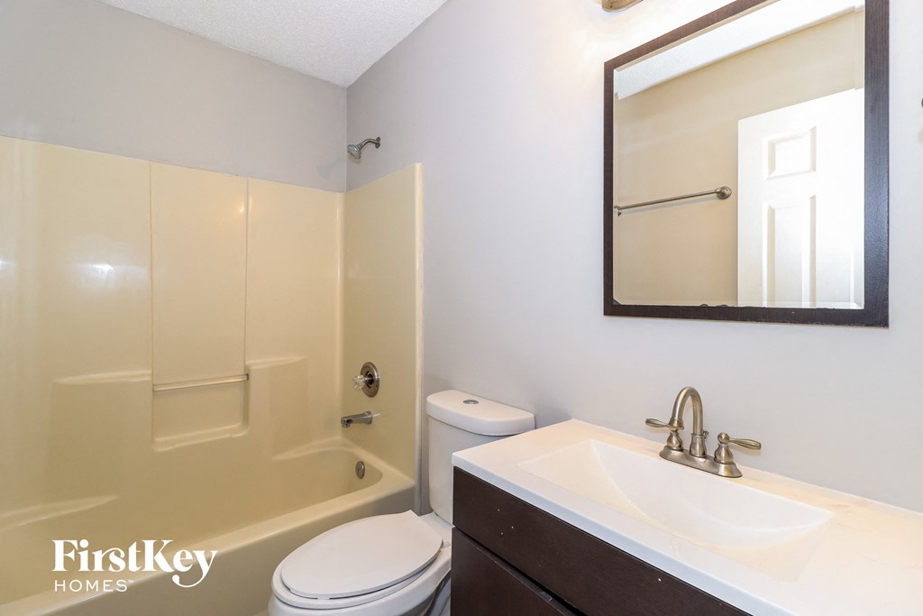 a bathroom with a shower toilet and sink and a mirror