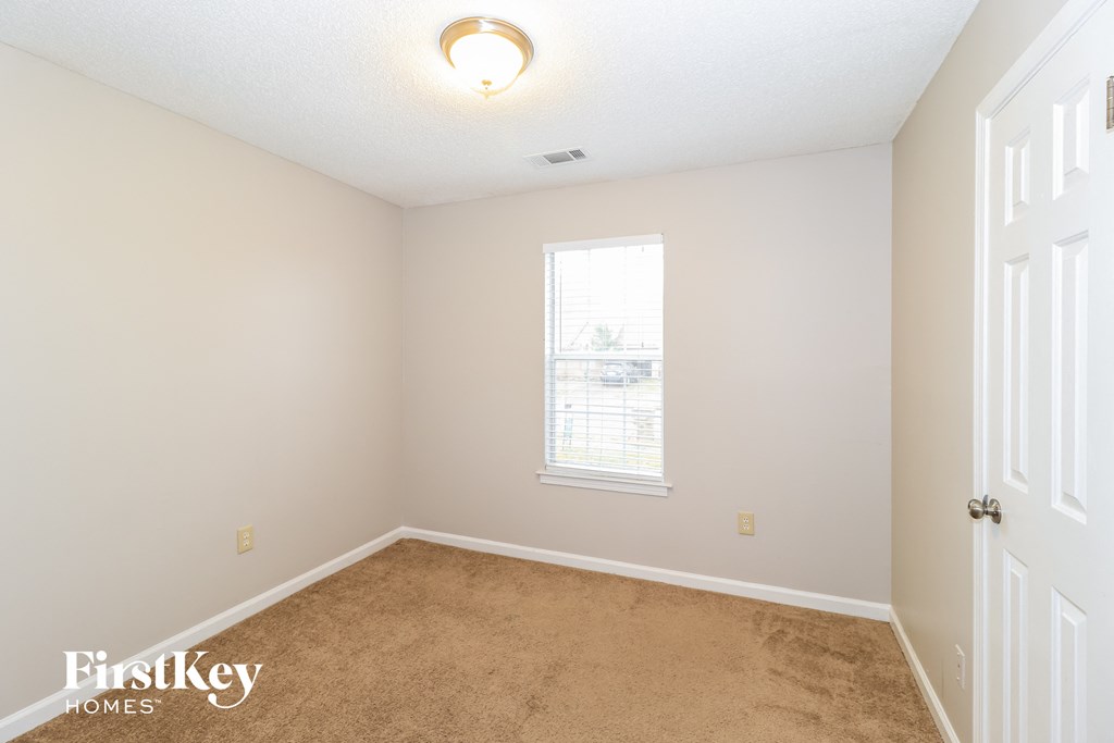 a bedroom with a carpeted floor and a window
