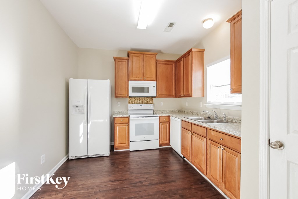 a kitchen with wooden cabinets and white appliances
