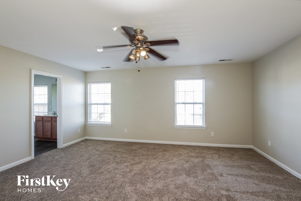 a living room with carpet and a ceiling fan