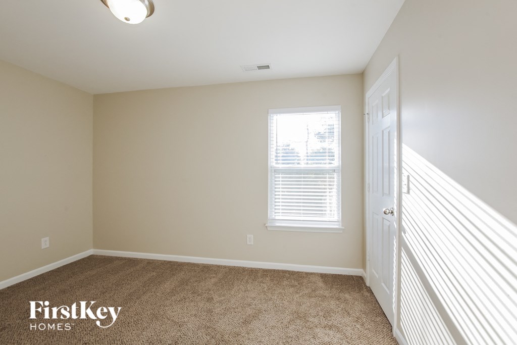 a bedroom with carpeted flooring and a door to a closet