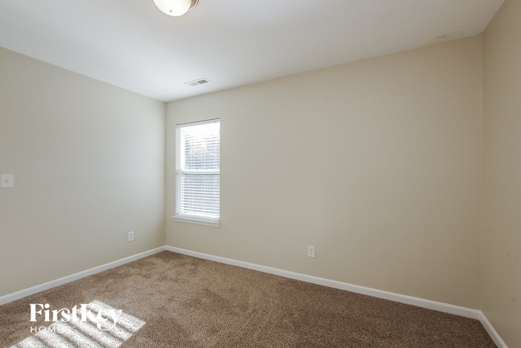 an empty room with carpet and a window