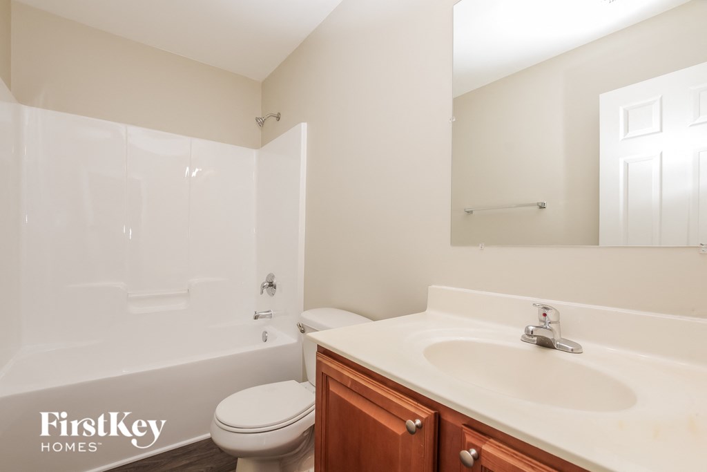 a bathroom with a sink toilet and tub and a mirror