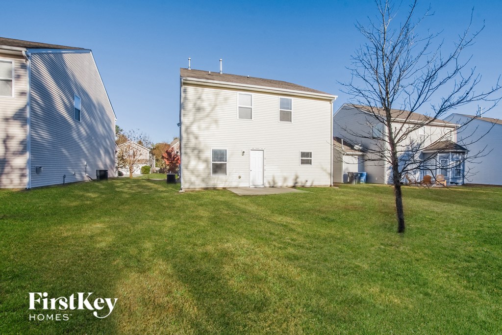 a white house with a yard and a tree