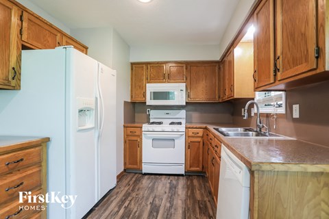 a kitchen with white appliances and wooden cabinets