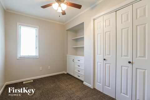 a bedroom with two closets and a ceiling fan