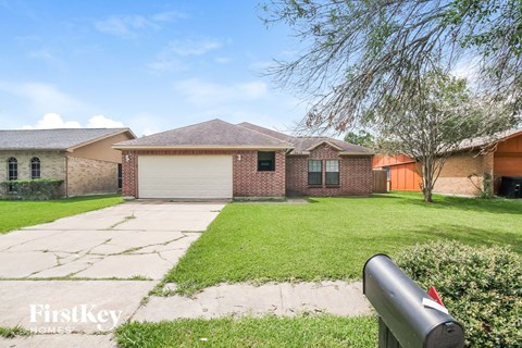 a brick house with a yard and a mailbox in front of it