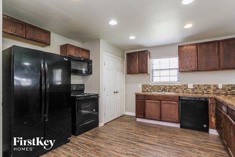 a kitchen with black appliances and wooden cabinets