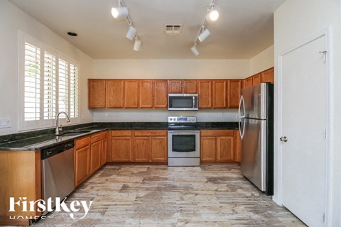 A kitchen with wooden cabinets and a black countertop.