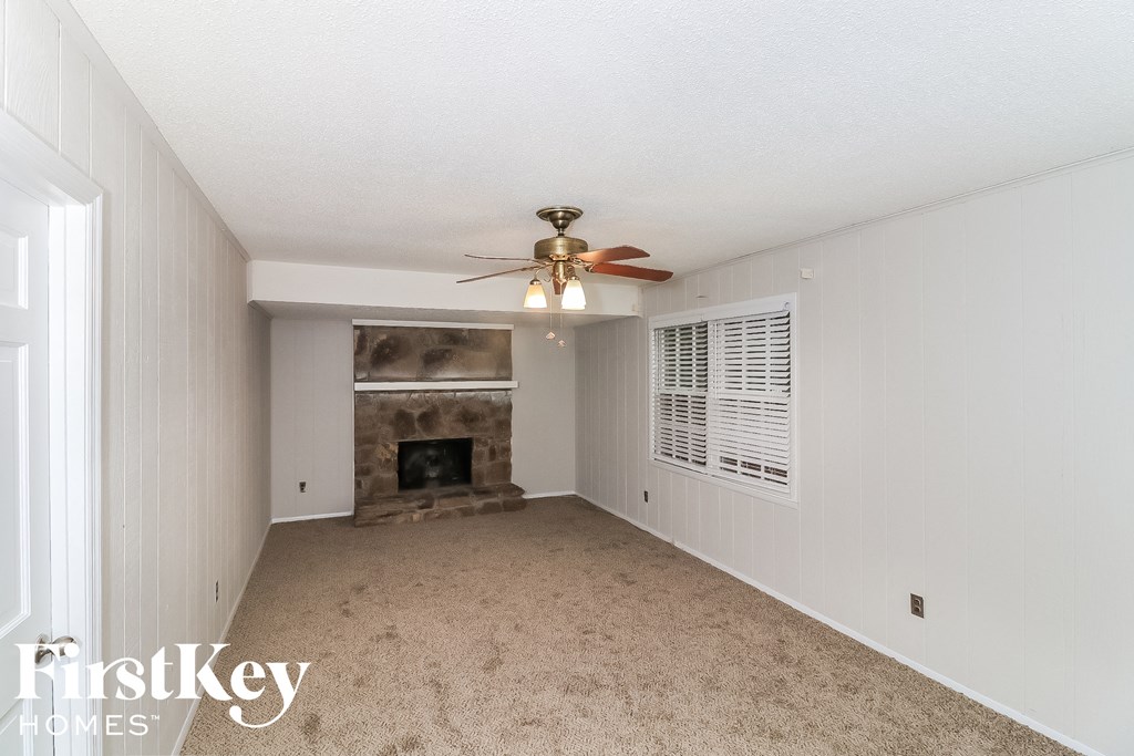 a living room with a ceiling fan and a fireplace