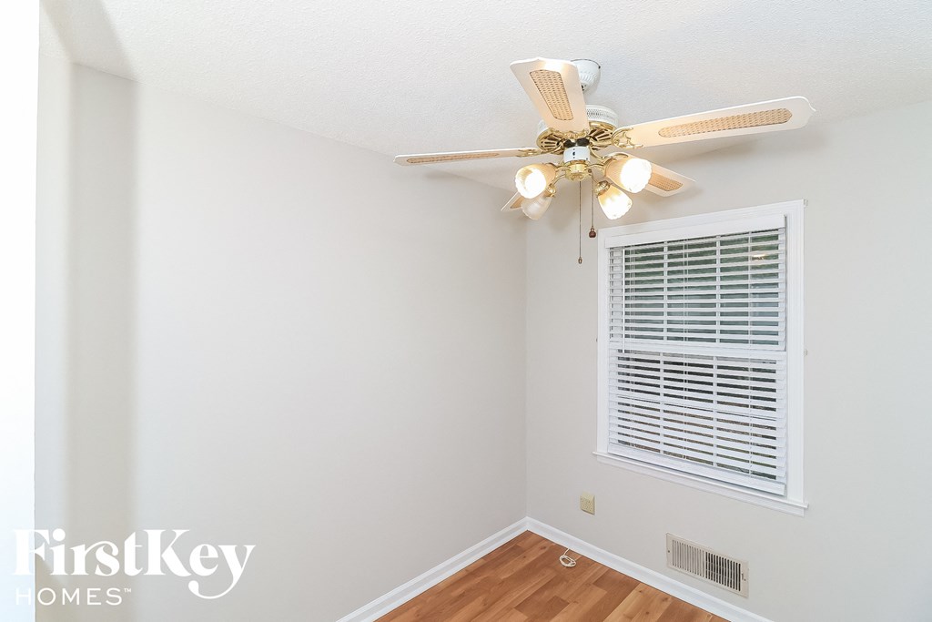 a bedroom with a ceiling fan and a window