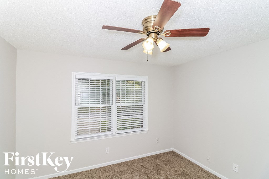 a bedroom with a ceiling fan and a window