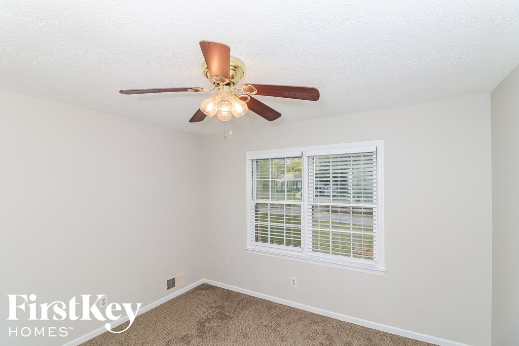 a bedroom with a ceiling fan and a window