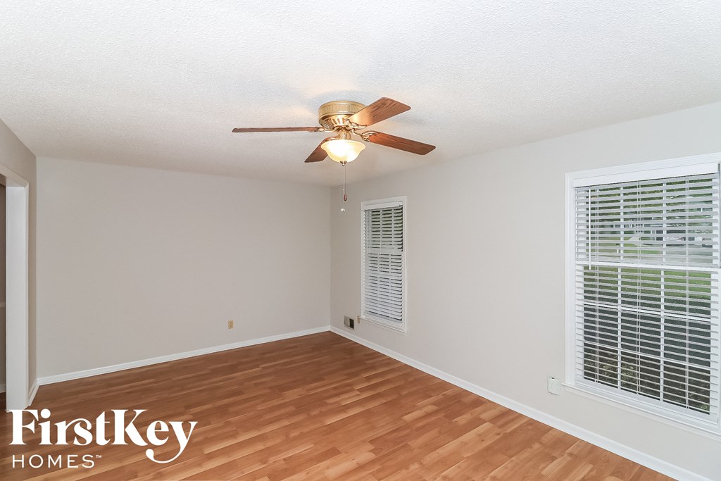 a living room with wood floors and a ceiling fan