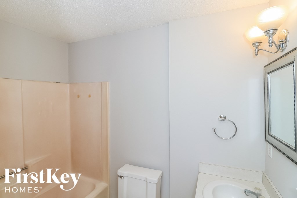 a small bathroom with a toilet and a sink and a mirror