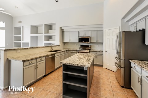 A kitchen with a granite counter top and stainless steel appliances.
