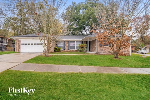 a brick house with a lawn and a white garage door