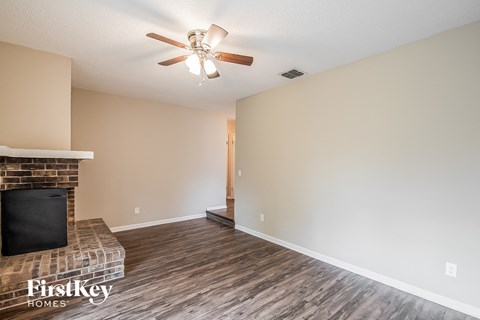 a living room with a fireplace and a ceiling fan