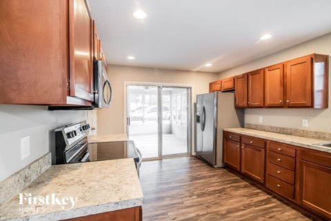 a kitchen with wooden cabinets and a stainless steel refrigerator