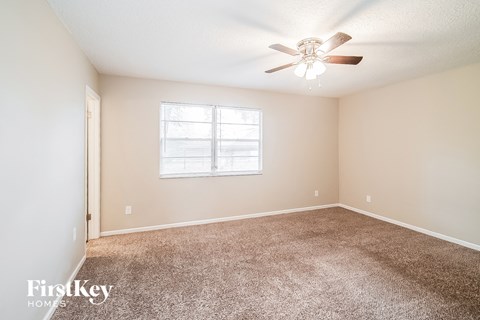 a bedroom with carpet and a ceiling fan