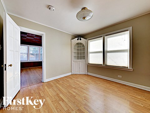 an empty living room with wood floors and a white door