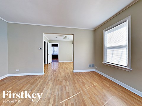 an empty living room with hardwood floors and a large window