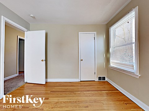 an empty living room with a large window and a door to a closet