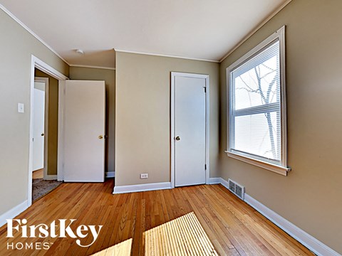 an empty living room with wood floors and a large window