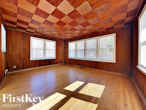 an empty room with wood floors and windows