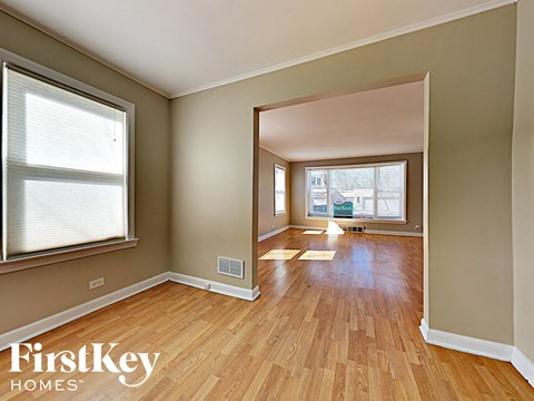 an empty living room with a hardwood floor and a window