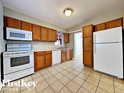 a kitchen with white appliances and wooden cabinets