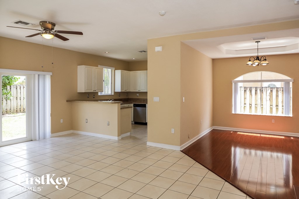 A spacious room with a kitchen area and a dining table.
