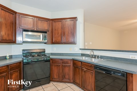 A kitchen with wooden cabinets and a black stove top oven.
