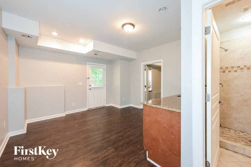 A room with a wooden floor and a tiled shower.