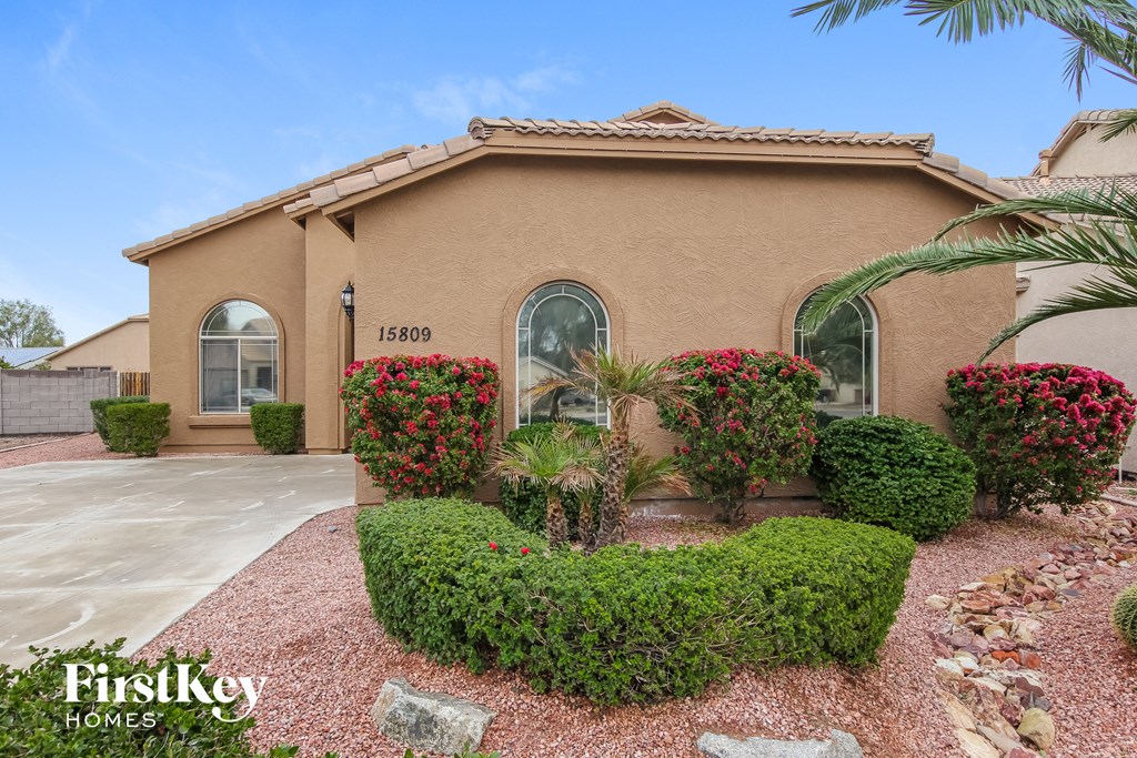 a home with a driveway and plants in front of it