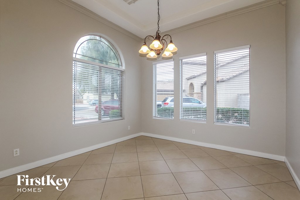 an empty dining room with windows and a ceiling light
