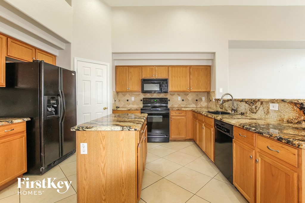 a kitchen with granite counter tops and black appliances