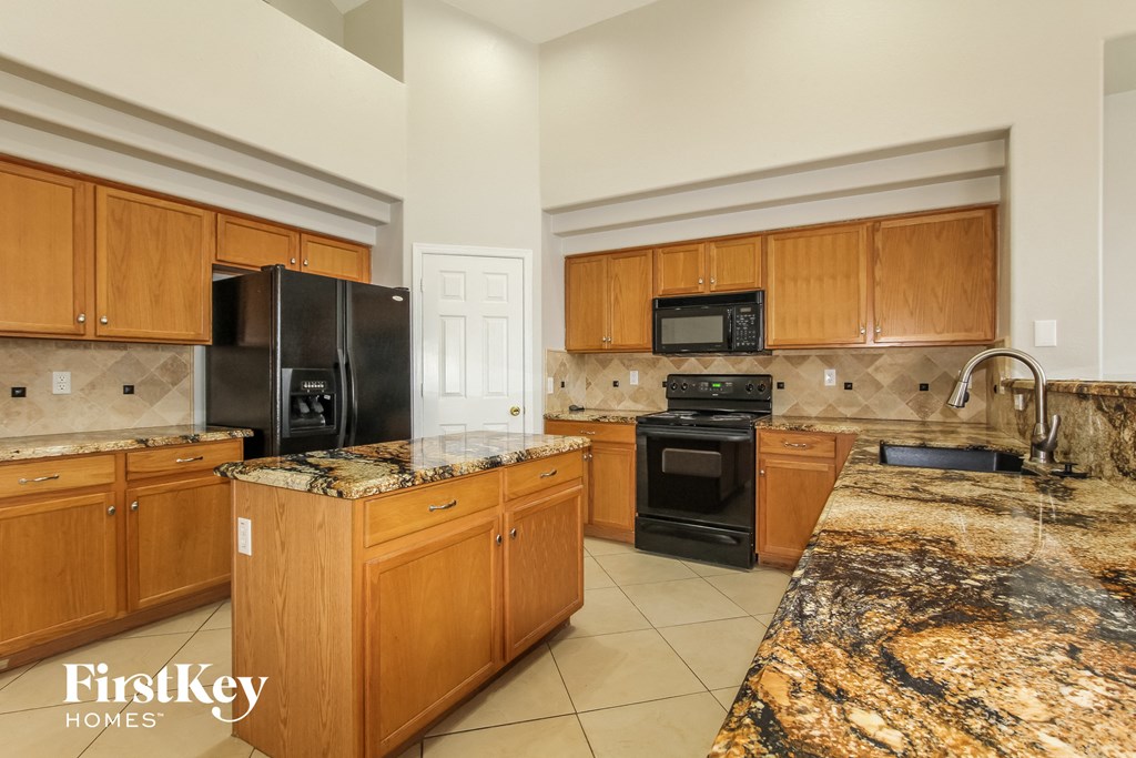 a kitchen with granite counter tops and wooden cabinets