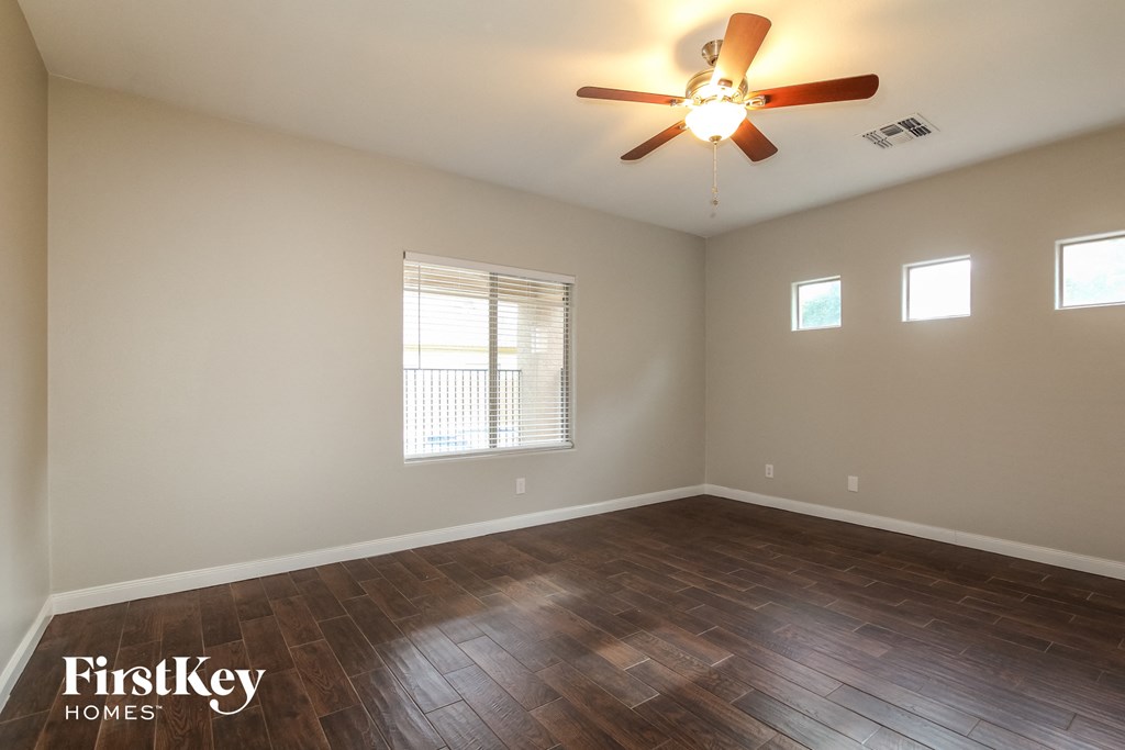 the living room with wood floors and a ceiling fan
